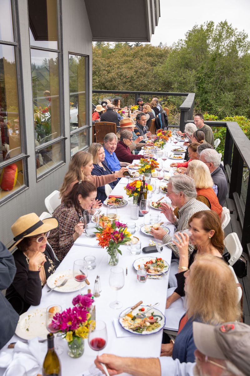 The Halleck Vineyard hosts a harvest party lunch to celebrate the grape harvest season. A packed table of friends gathers for an abundant feast, featuring a variety of food and wine. The event takes place at the winery's picturesque vineyard in the heart of California's Sonoma County Wine Country. Guests enjoy glasses of the winery's acclaimed Pinot Noir, as well as other wines sourced from nearby vineyards. The festive atmosphere is a reminder of the strong sense of community among wineries in the region. Amid the sprawling vineyards and rolling hills, guests savor the flavors of the land, and raise a toast to another successful harvest.