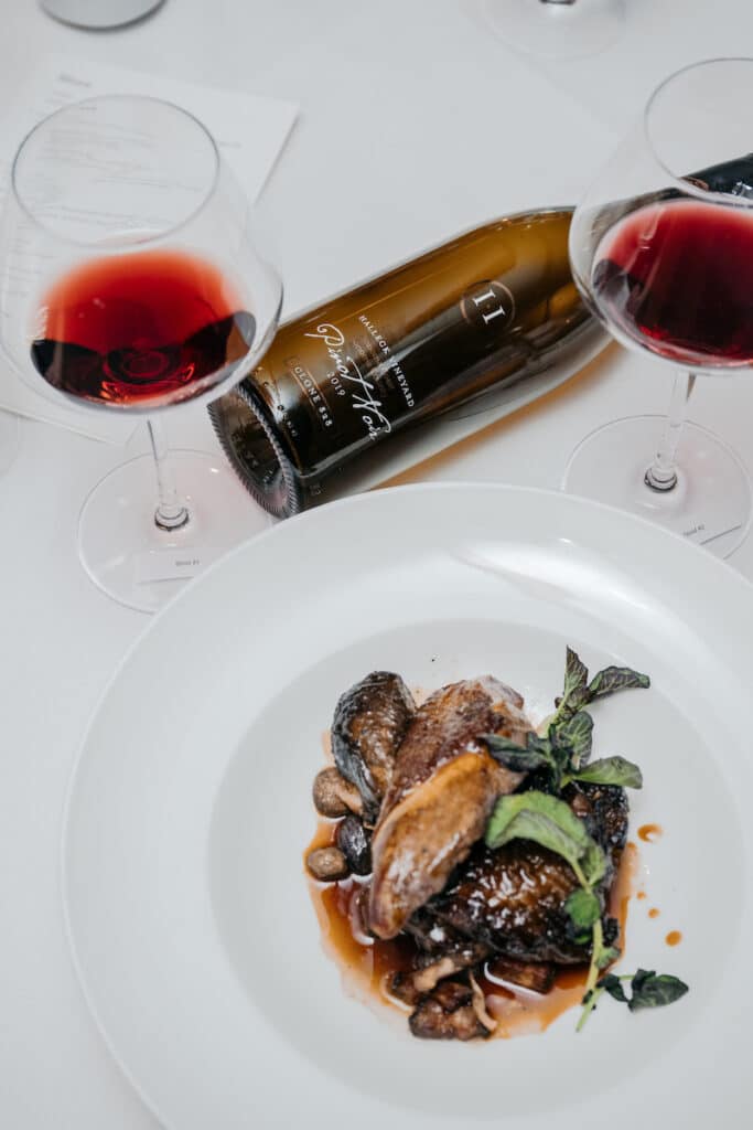 At Bar Boulud, the classic French dish Coq au Vin with lardons, mushrooms, and pearl onions is expertly paired with Halleck Vineyard's Double Gold-winning 2019 Clone 828 Pinot Noir, Sonoma Coast. With only 212 cases produced, this premium wine is a rare and sought-after vintage. Its rich flavor profile, with notes of black cherry and earthy undertones, complements the savory flavors of the dish perfectly. This unforgettable dining experience showcases the best of French culinary expertise and Californian winemaking, creating a unique and unforgettable culinary experience for all who indulge.