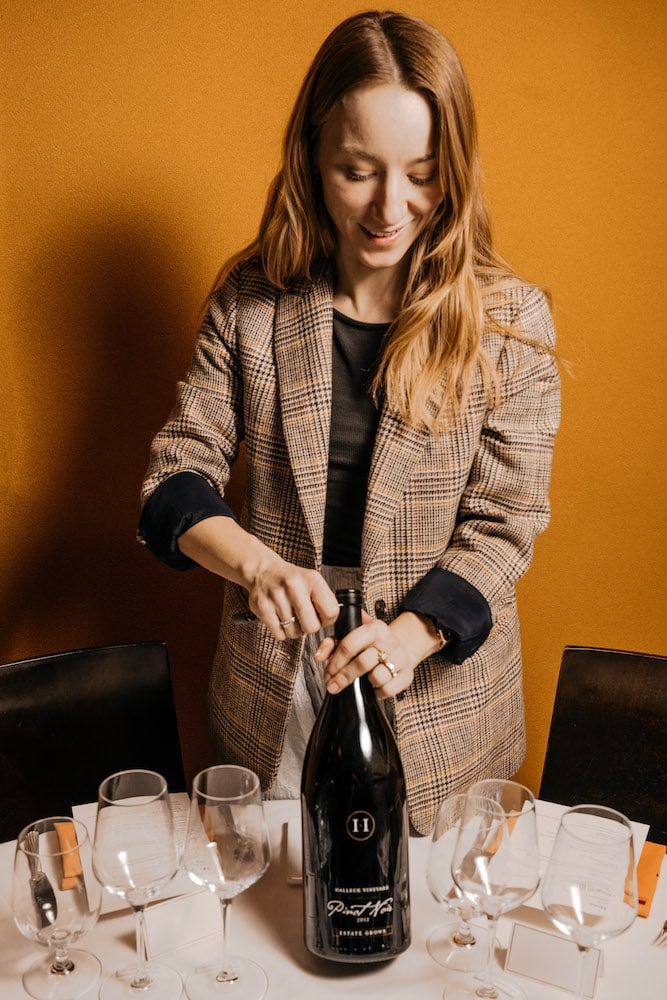 At a private wine dinner hosted by Michelin star Chef Daniel Boulud at his renowned bistro Bar Boulud in New York City, sommelier Victoria Taylor expertly opens a magnum bottle of Halleck Vineyard's Estate Pinot Noir. The premium wine is crafted from the finest grapes grown in the Russian River Valley, showcasing the region's unique terroir and flavors. The Estate Pinot Noir's exceptional quality and taste are a testament to Halleck Vineyard's commitment to producing premium wines. This unforgettable dining experience highlights the perfect balance between expert wine pairings and expertly crafted dishes, making it a culinary experience like no other.